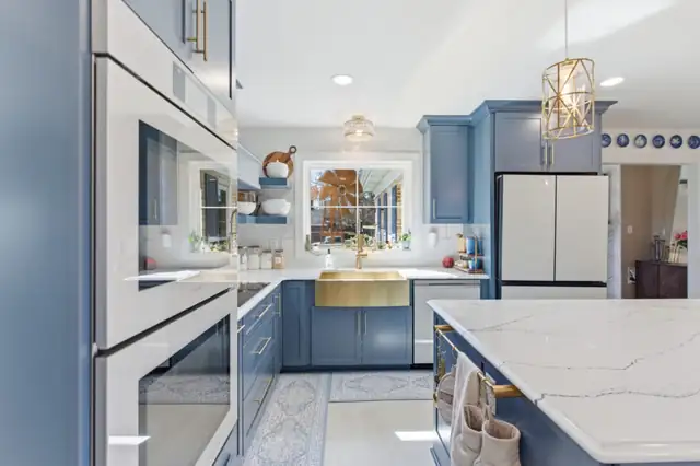 Charles Town, WV kitchen with blue KraftMaid cabinets, white double wall ovens, gold sink and quartz island