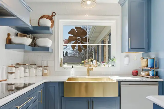 Charles Town kitchen with blue cabinets, a brass farmhouse sink, open wood shelves and a window over the sink