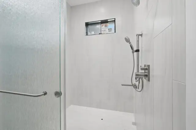 Harpers Ferry, WV curbless walk-in shower with large white 12x24 tile in a brick pattern, tiled niche and glass door